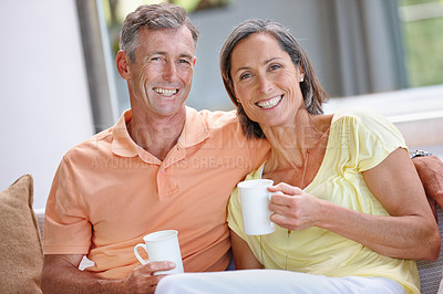 Buy stock photo Portrait of a  loving mature couple having coffee while sitting on the sofa