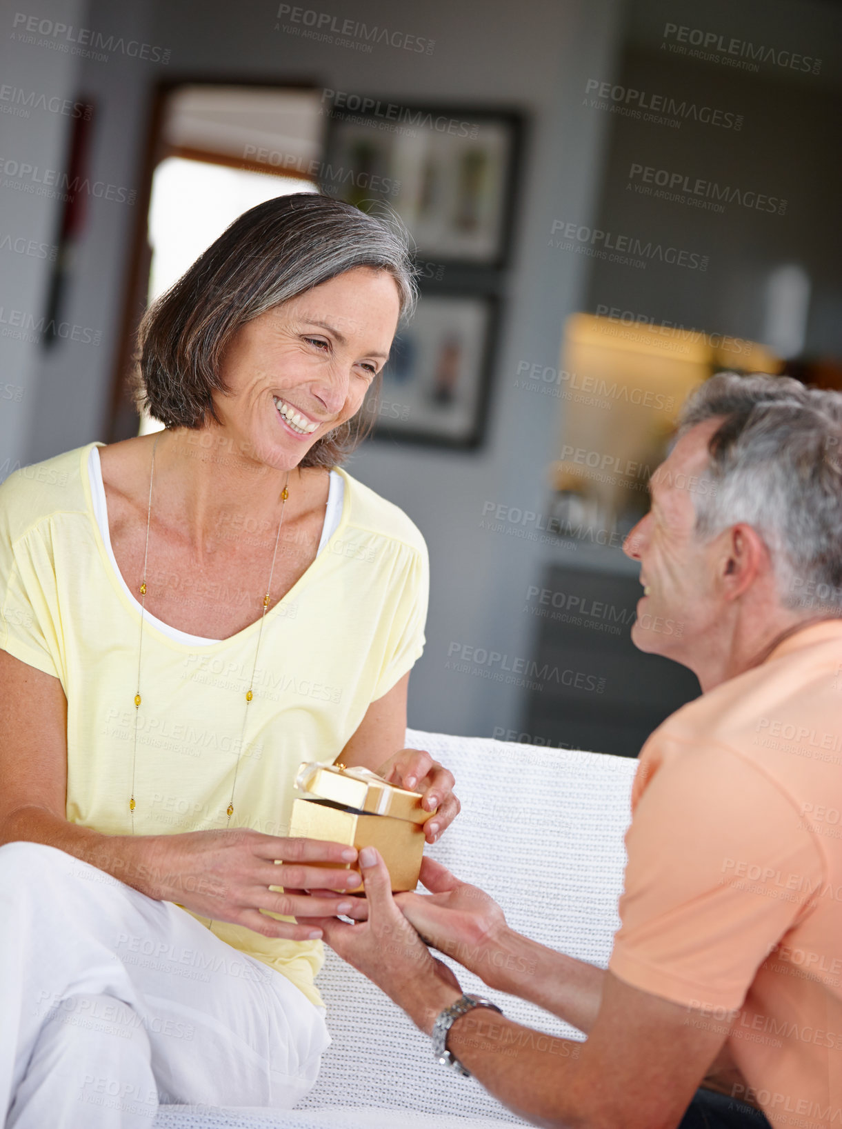 Buy stock photo House, gift and senior couple with love, smile and celebration for anniversary. Apartment, mature woman and old man with present, relationship and marriage with birthday and care in living room