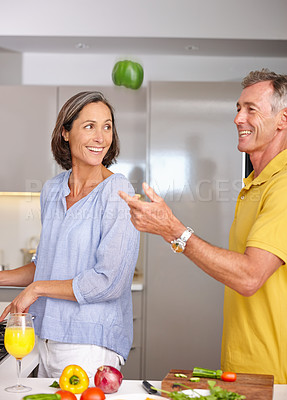 Buy stock photo Shot of a mature couple being playful while preparing a meal  in the kitchen