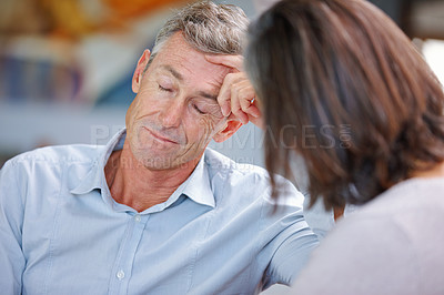 Buy stock photo Shot of a mature man looking bored while his wife's talking to him