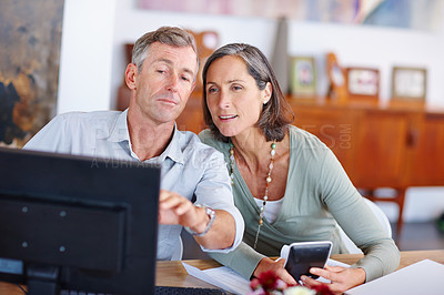 Buy stock photo Shot of a mature married couple going through their finances at home