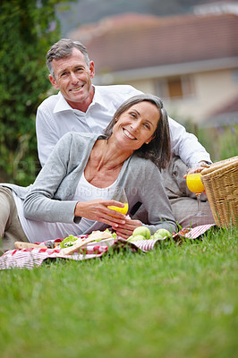 Buy stock photo Portrait, mature couple and picnic with juice for nutrition, food and bonding together with connection. Happy people, man and woman with beverage for drinking, love and commitment in marriage at park