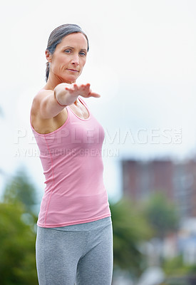 Buy stock photo Shot of an attractive mature woman doing yoga outdoors