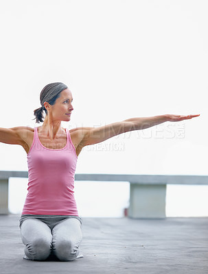 Buy stock photo Shot of an attractive mature woman doing yoga outdoors