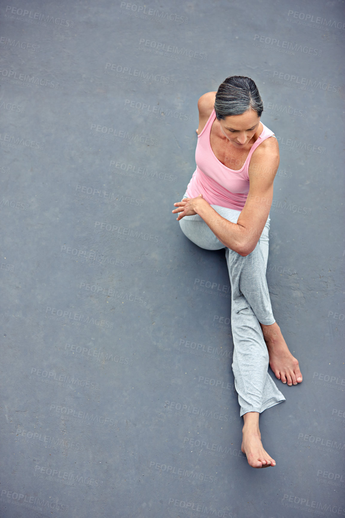 Buy stock photo High angle view of an attractive mature woman doing yoga outdoors