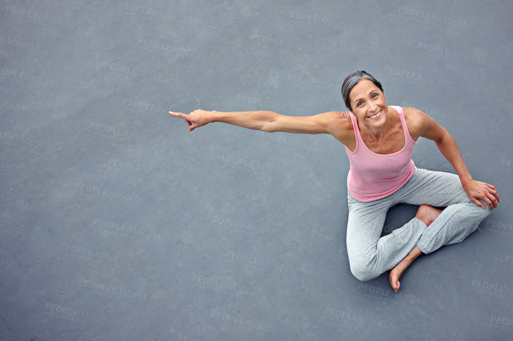 Buy stock photo High angle portrait of an attractive mature woman in gymwear pointing at copyspace