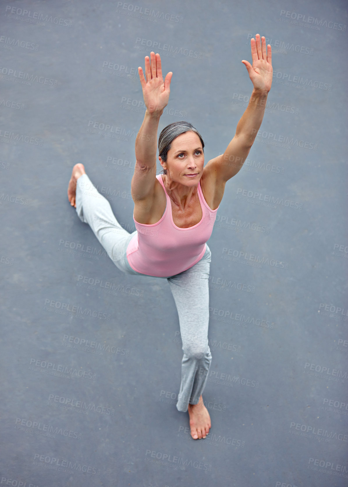 Buy stock photo High angle view of an attractive mature woman doing yoga outdoors