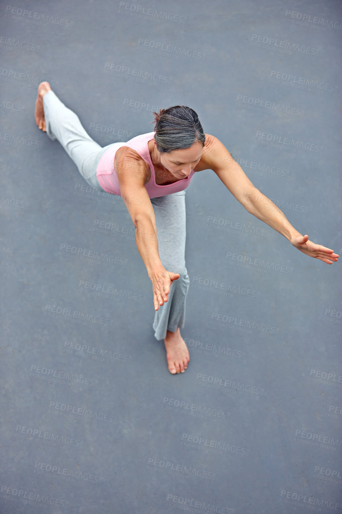 Buy stock photo High angle view of an attractive mature woman doing yoga outdoors