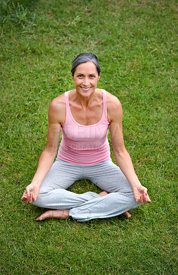 Buy stock photo Shot of an attractive mature woman practicing yoga in the lotus position