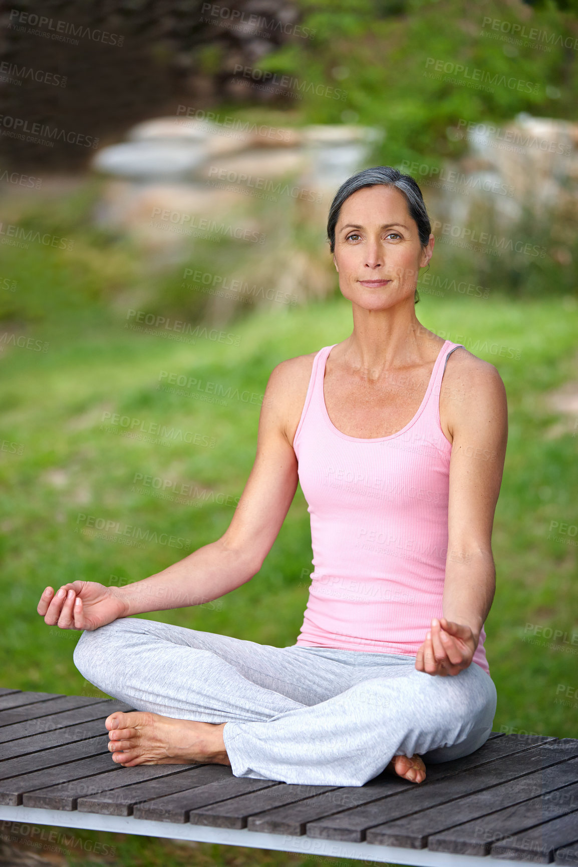 Buy stock photo Shot of an attractive mature woman practicing yoga in the lotus position