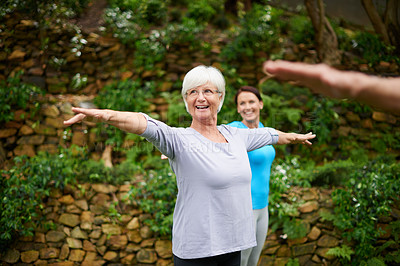 Buy stock photo Shot of a senior woman enjoying an outdoor yoga class