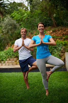 Buy stock photo Full length shot of a man and woman performing a balancing pose in an outdoor yoga class
