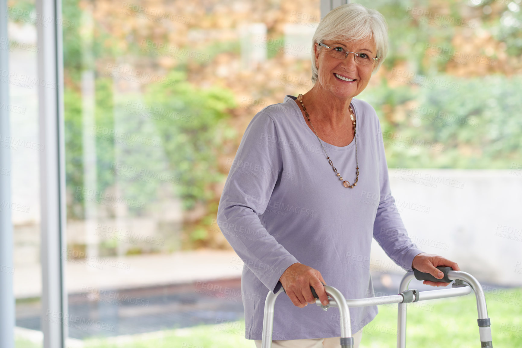 Buy stock photo Portrait shot of a senior woman using an orthopedic walker, looking positive