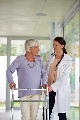 Buy stock photo Shot of a senior woman being helped by her doctor to use an orthopedic walker