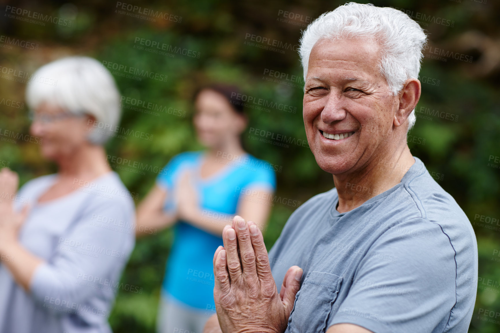 Buy stock photo Shot of a senior man doing yoga with other people outdoors