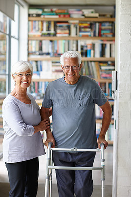 Buy stock photo Portrait of a senior woman assisting her husband who's using a walker for support