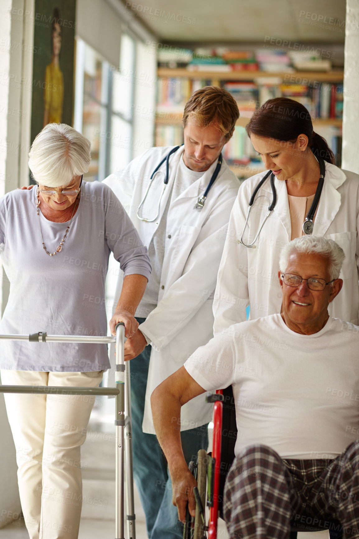 Buy stock photo Shot of a team of doctors assisting their senior patients with physical impairments