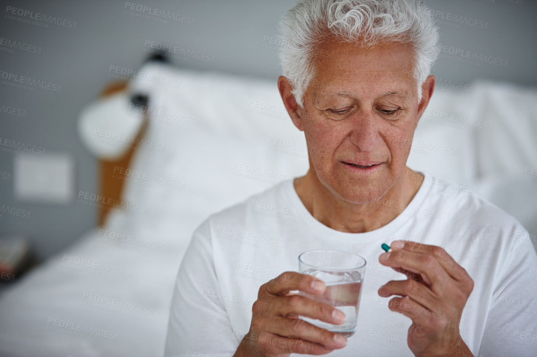 Buy stock photo Bedroom, old man and medicine with tablets, water and healthcare with supplements. Nursing home, pensioner and senior person with liquid, antibiotics and drugs for wellness, illness and painkiller