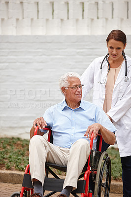 Buy stock photo Shot of a female doctor pushing her senior patient in a wheelchair outside