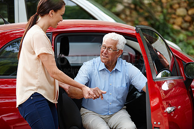 Buy stock photo Shot of a woman helping her senior father out of the car