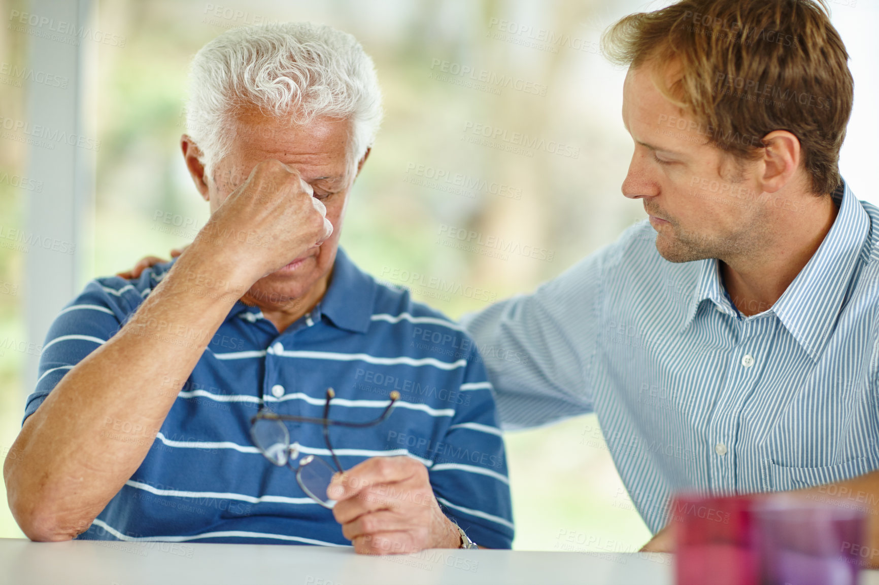 Buy stock photo Shot of a son comforting his senior father