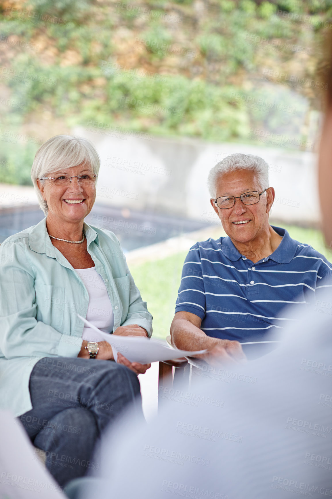 Buy stock photo Over-the-shoulder shot of a financial advisor meeting with a senior couple at their home