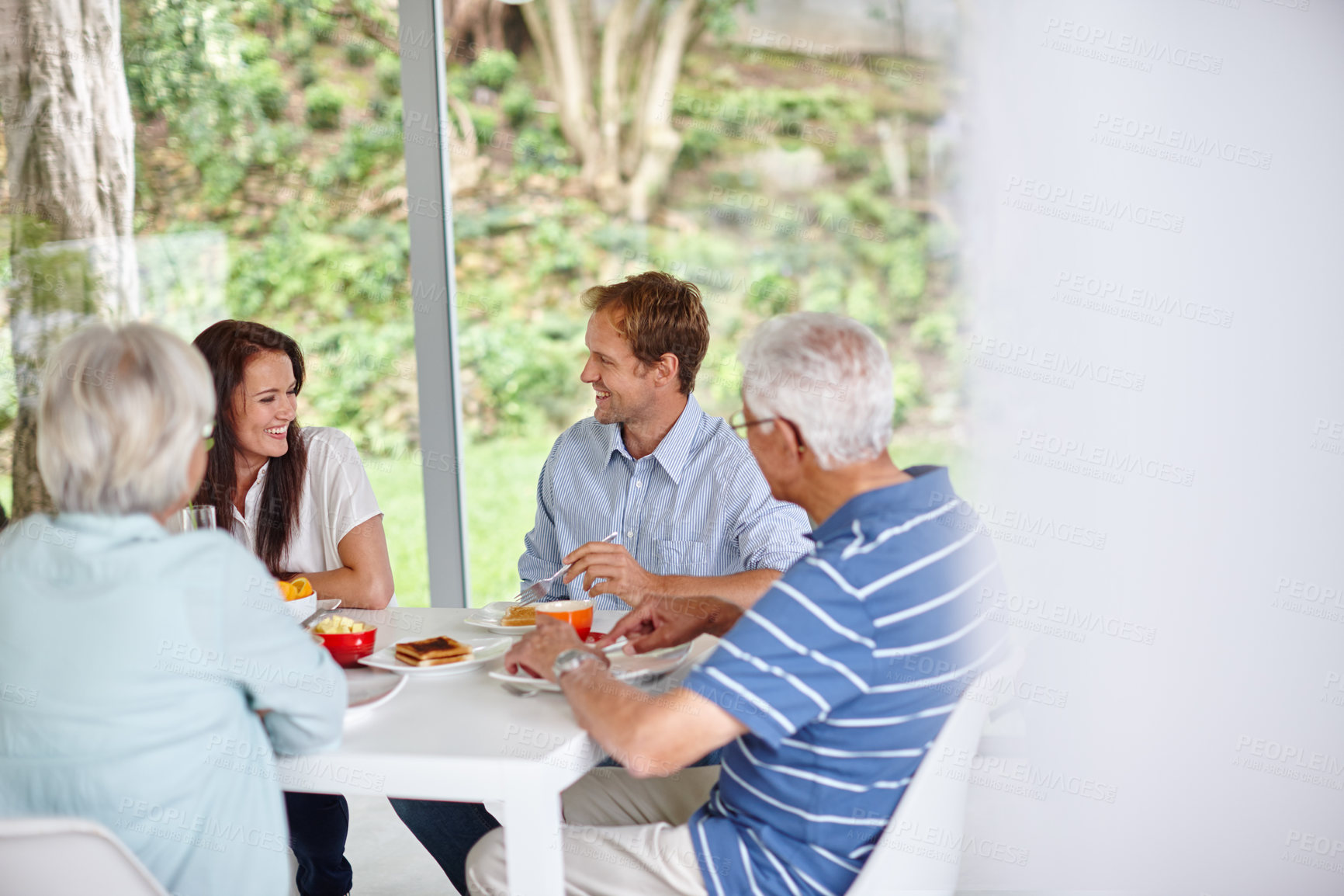 Buy stock photo Breakfast, smile and talking with family in dining room of home together for morning bonding or visit. Conversation, food and love with group of people in apartment for diet, health or nutrition