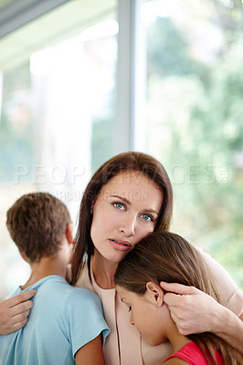 Buy stock photo Shot of a loving mother consoling her children at home