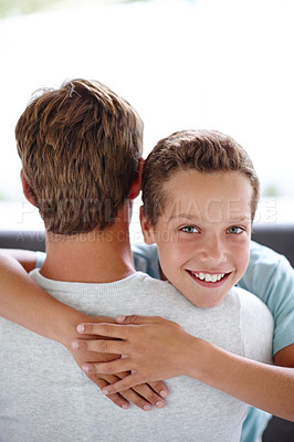 Buy stock photo Portrait of a happy little boy hugging his father at home