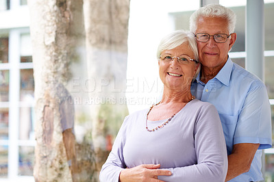 Buy stock photo Embrace, portrait and senior couple at window with love, care and happy marriage in retirement together. Hug, elderly man and woman in home with smile, support and comfort with morning bonding.