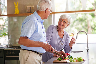 Buy stock photo Shot of a senior couple preparing a meal in their kitchen