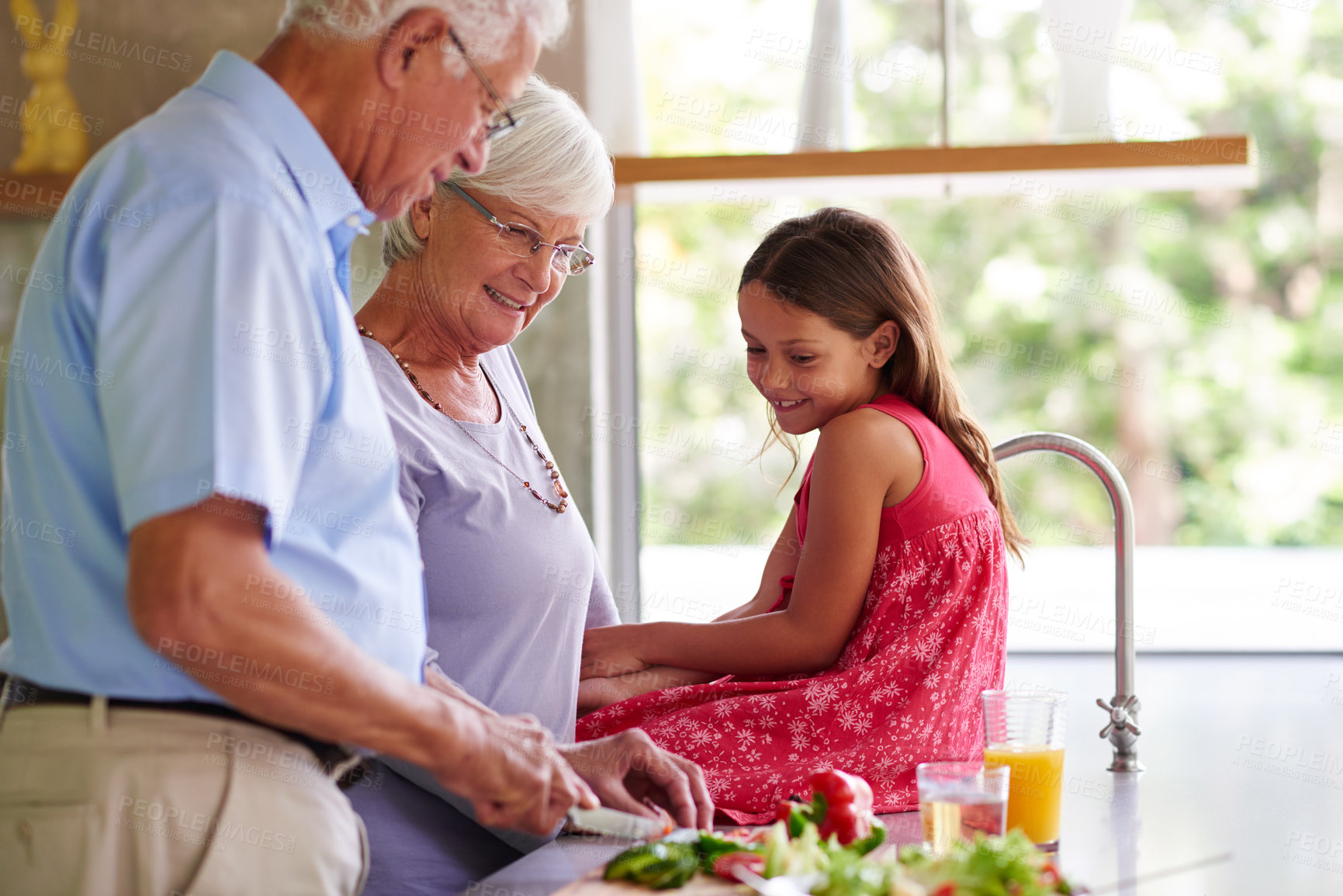 Buy stock photo Grandparents, girl and cooking in kitchen, teaching and happy with vegetables, knife and bonding in family house. Senior man, woman and child with ingredients, recipe and learning for development