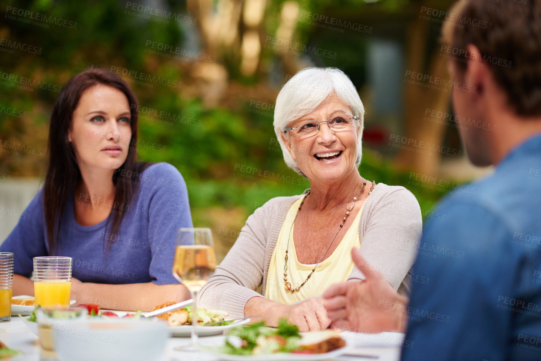 Buy stock photo Shot of a mother having lunch outside with her adult son and daughter