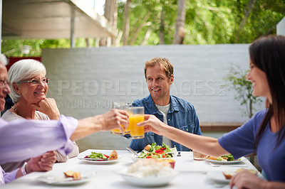 Buy stock photo Shot of father and mother toasting their adult children while having lunch outside