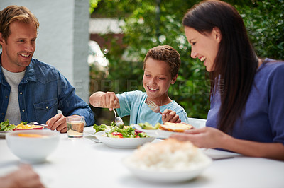 Buy stock photo Shot of a family enjoying a meal outside