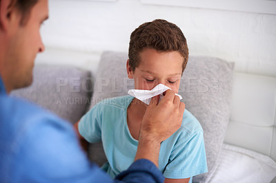 Buy stock photo Father, boy or blowing nose with tissue for sneeze or cold flu for virus, hayfever or sinus at home. Dad, son or helping sick child with mucus, symptoms or viral infection for allergy or cough in bed