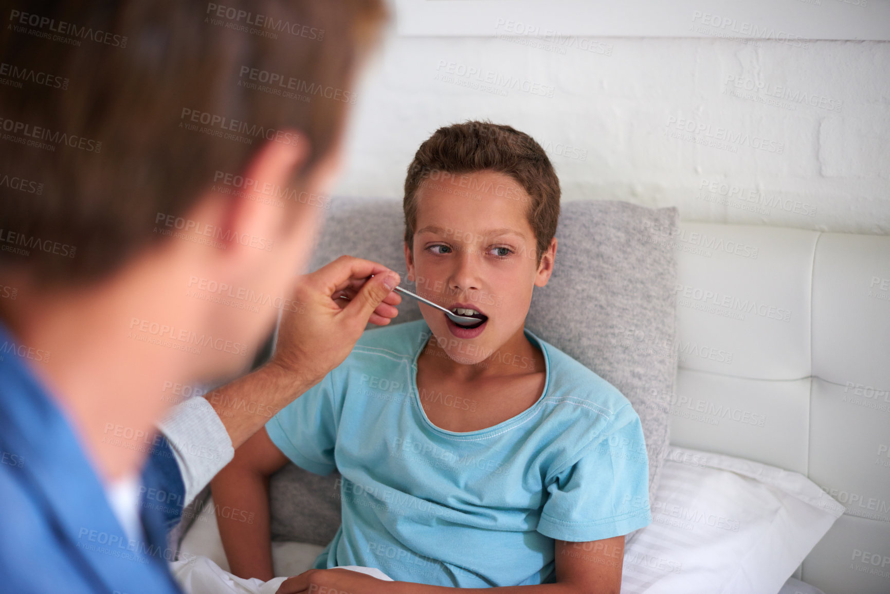 Buy stock photo Father, sick boy and medicine with spoon in bed for fever, pain relief or viral infection at home. Dad, son or child with medication, antibiotic or syrup for cough, virus or cold and flu in bedroom