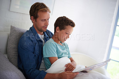 Buy stock photo A father reading a book to his son in bed