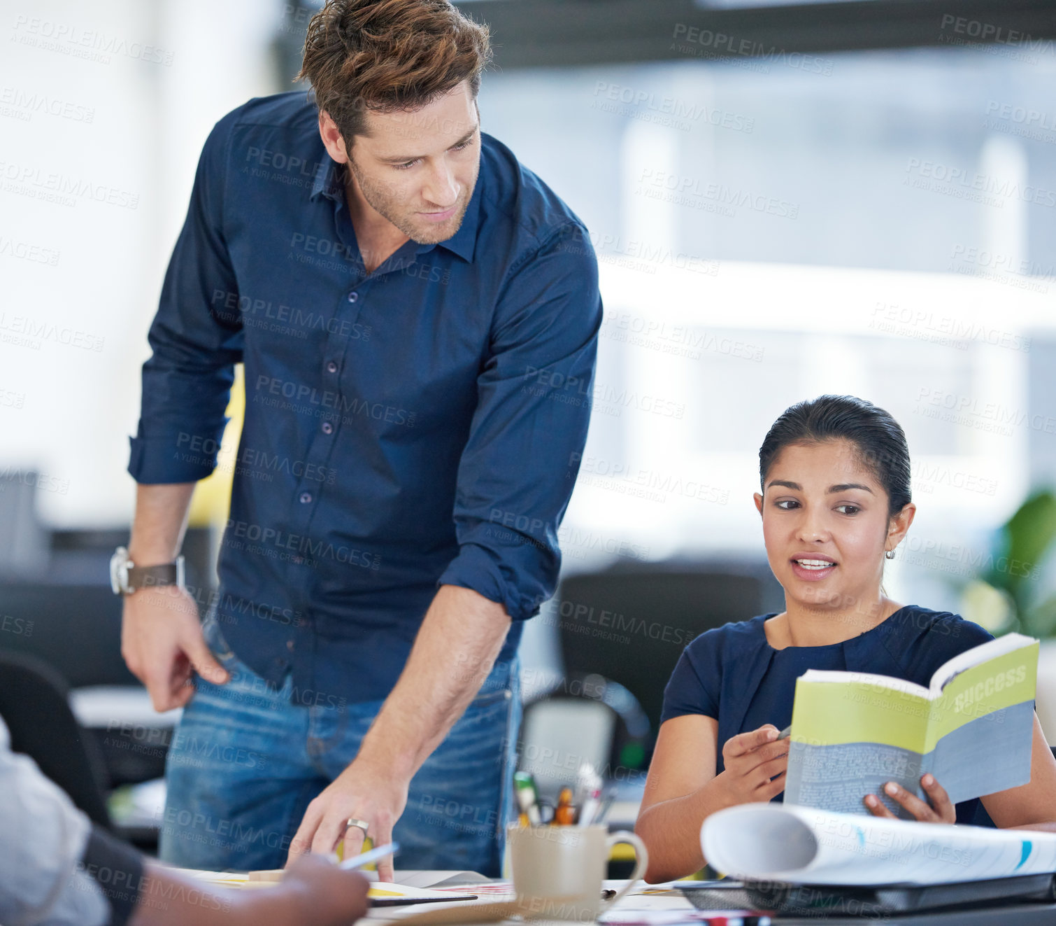 Buy stock photo Businessman, meeting and woman in office reading book, discussion or strategy for company success. Lead designer, architect or staff in agency for research, brainstorming or literature for growth