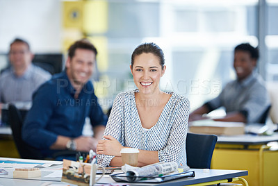 Buy stock photo Portrait of a young office worker at her desk with colleagues in the background