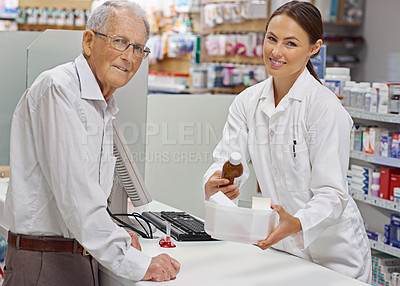 Buy stock photo Portrait of a young pharmacist helping an elderly customer at the prescription counter