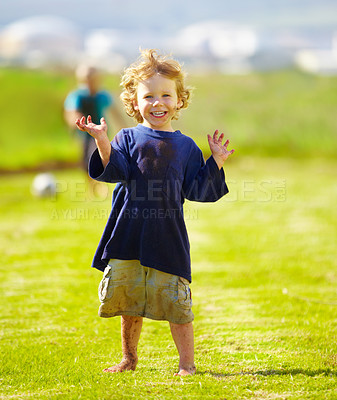 Buy stock photo Dirt, happy and portrait of child for soccer by grass, lawn and outdoor playing outside with laughter in nature. Boy, freedom and fun football for activity, comic and excited in youth with friend