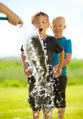Buy stock photo Little boys getting wet by a hose pipe while outdoors