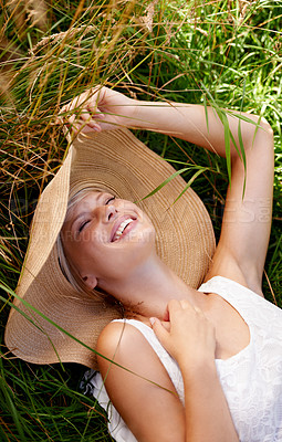 Buy stock photo Grass, hat and woman relax on lawn with peace, happiness and freedom in summer. Outdoor, fashion and girl lying in field with smile on face for holiday, vacation or free time in nature with wellness