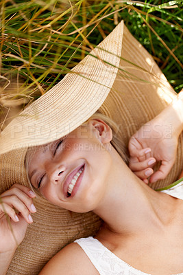 Buy stock photo Woman, hat and relax on grass with peace, happiness and freedom in summer. Outdoor, fashion and girl lying on lawn with a smile on face for holiday, vacation or free time in nature with wellness