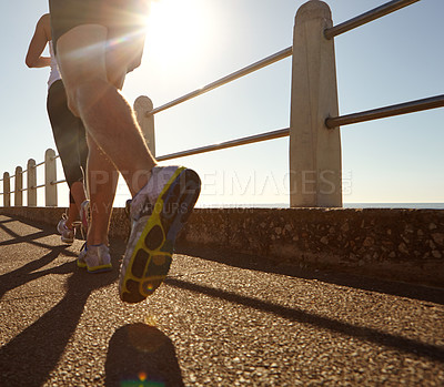 Buy stock photo Cropped shot of two people jogging on the promenade