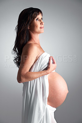 Buy stock photo Studio, pregnant and woman with hope for stomach, growth and health of baby, body and glow with cosmetics. Grey background, mom and child in belly or abdomen, shine and skincare for parent and love