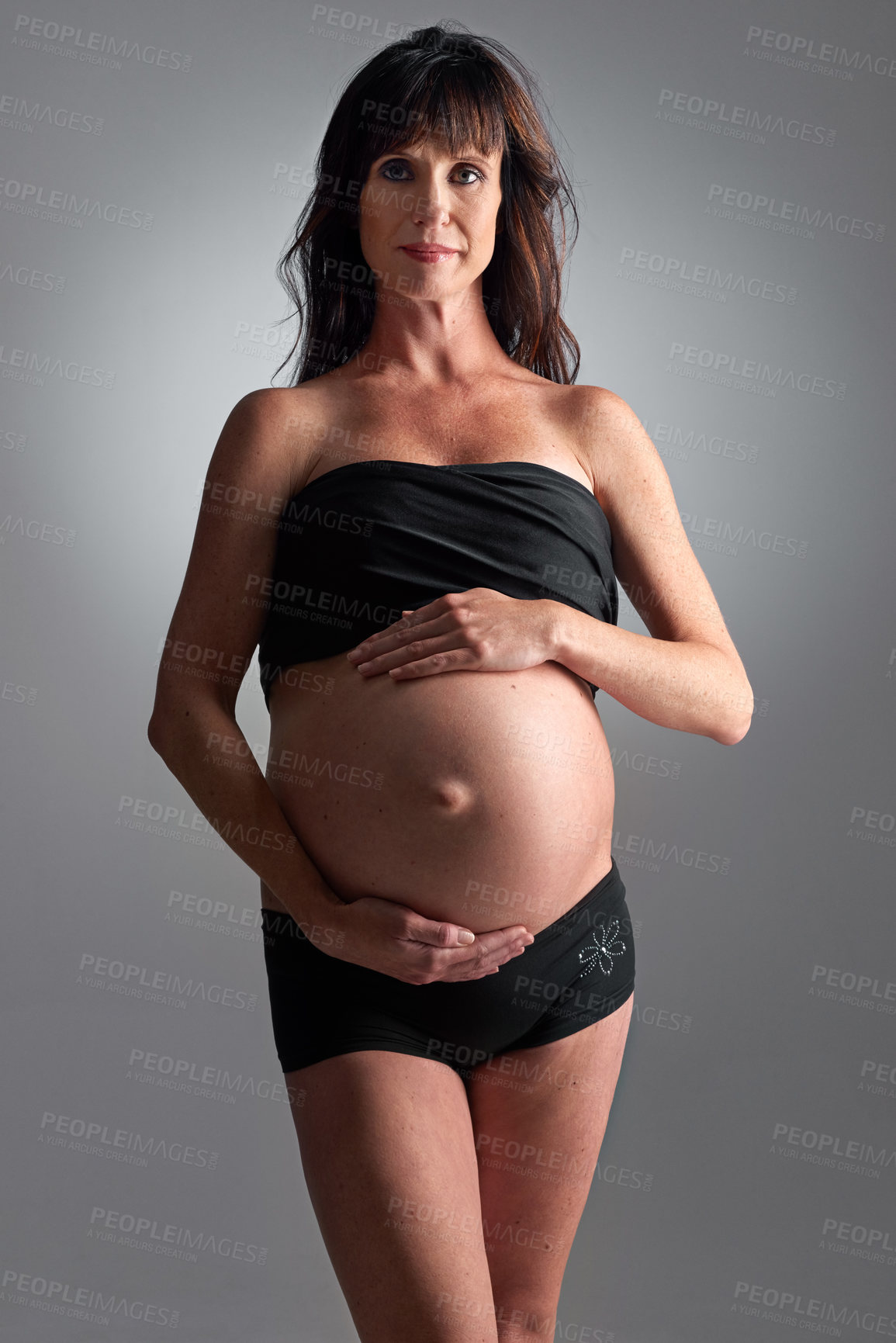 Buy stock photo A pregnant woman holding her tummy