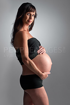 Buy stock photo A pregnant woman holding her tummy