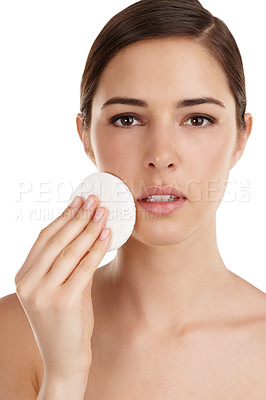 Buy stock photo Cropped portrait of a beautiful young woman exfoliating her face against a white background